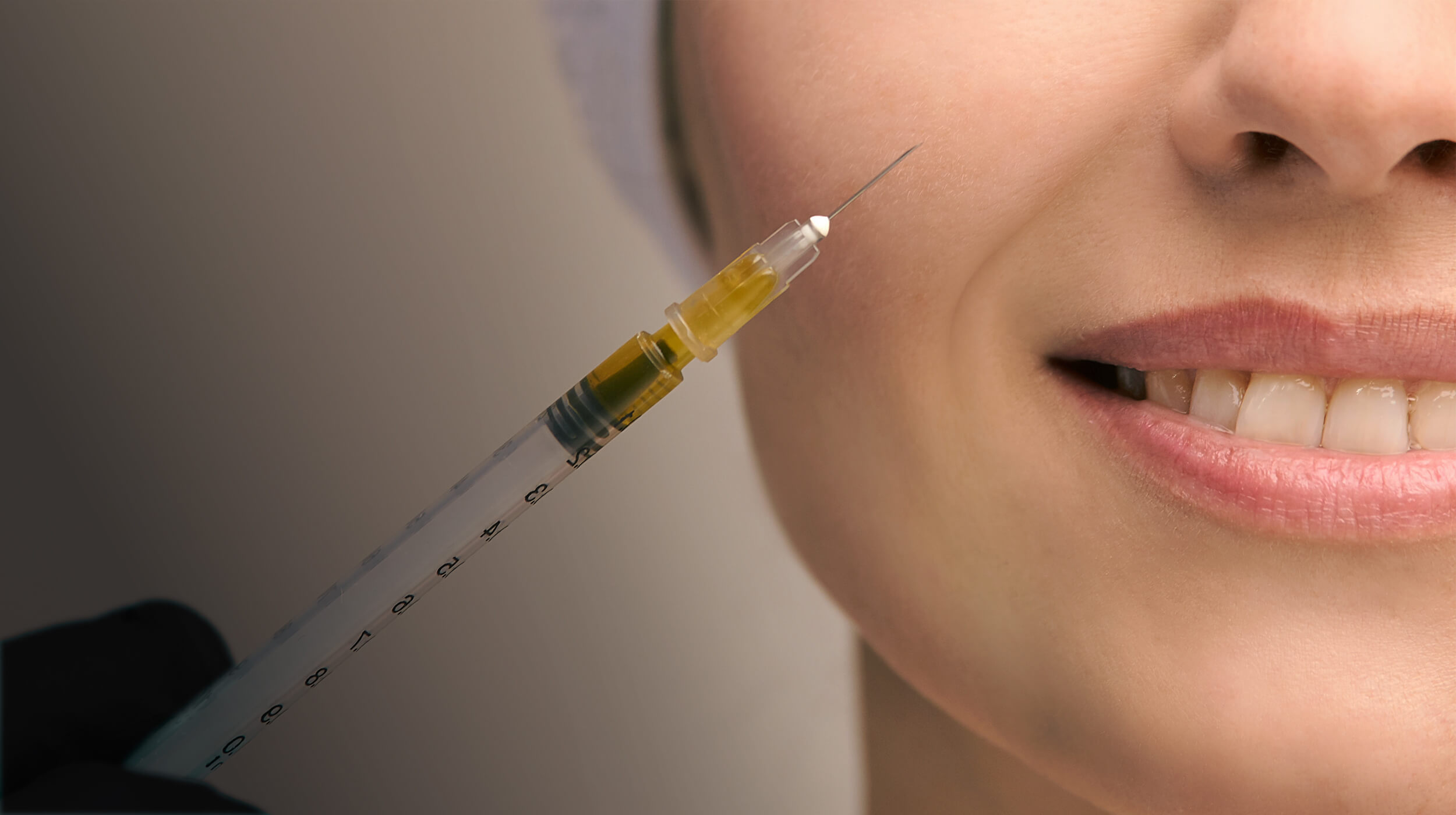 Close-up of a woman's face receiving an injection therapy