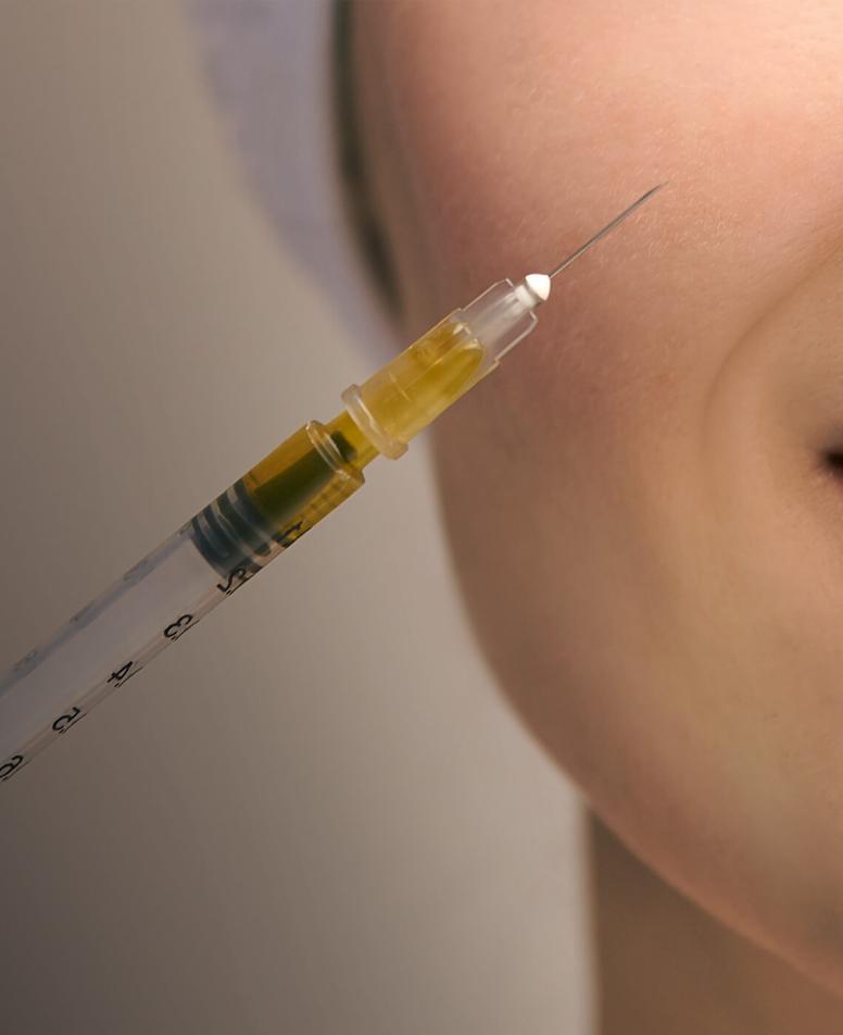 Close-up of a woman's face receiving an injection therapy